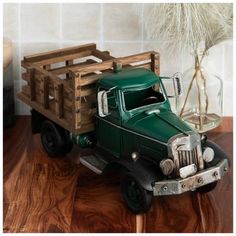 a green truck is sitting on a wooden table