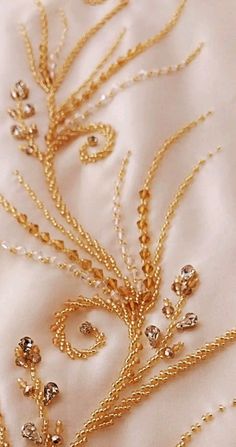 a close up of a gold necklace on a white cloth