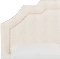 an upholstered headboard with white linen