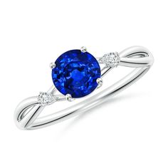 a blue sapphire and diamond ring with two diamonds on the band, set in white gold