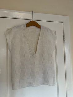 "women's hand knitted sleeveless off white chunky sweater jumper  Made of wool but not sure exactly which kind perhaps an acrylic mix Rib knit on the hem and armholes and neckline  can be worn by either men or women  size M/L 21\" armpit to armpit across the front although there is some stretch  25\" long from neck at the back to hem  can also be worn oversized  Excellent preloved condition" Sleeveless Knitted Cotton Sweater, Cotton V-neck Sweater Vest With Textured Knit, Casual Sleeveless Knit Sweater, White Winter Sweater Vest, White Textured Knit Sweater Vest With Crew Neck, White Chunky Knit V-neck Top, White Textured Knit Crew Neck Sweater Vest, White Textured Knit V-neck Sweater Vest, Trendy Fitted Textured Knit Sweater Vest