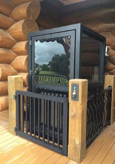 a wooden structure with a mirror on it's front and back sides, sitting on a deck next to logs