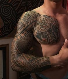 a man with tattoos on his chest and arm