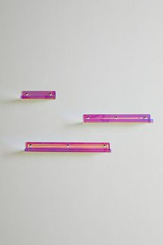 three pieces of pink and purple colored hair clips