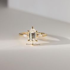 a diamond ring sitting on top of a white surface