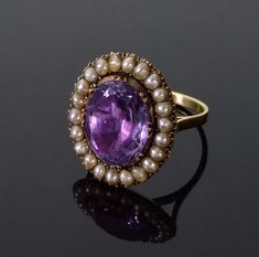 Gorgeous Georgian 14K gold amethyst pearl ring size 7 1/2. The ring designed around the nice color amethyst surrounded with halo of natural purls. The amethyst is 15 mm X 12 mm, it is foil backed and set in crimp collet bezel, characteristic for Georgian era. The ring face is 22 mm X 19 mm. The back of the ring is covered with solid gold dome. Neatly crafted band is 2 mm wide. There are no hallmarks. The ring was acid tested 14K gold throughout except of the amethyst mount to avoid damage. Total Antique 14k Gold Purple Ring, Victorian Gold Amethyst Ring, Victorian Amethyst Ring In Yellow Gold, Victorian Gold Amethyst Ring In 14k Gold, Georgian Pearl Ring, Georgian Ring, Italy Jewelry, Seed Pearl Ring, Gold Amethyst Ring