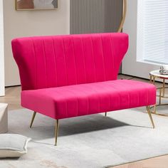 a pink couch sitting on top of a white rug