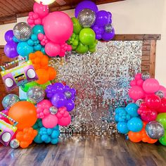 an assortment of balloons and disco balls on a wooden floor