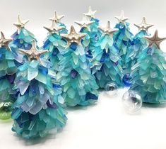 three small christmas trees made out of glass beads and starfishs on top of each other