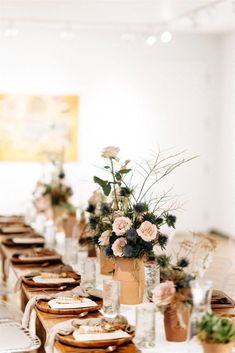 a long table is set with plates and vases