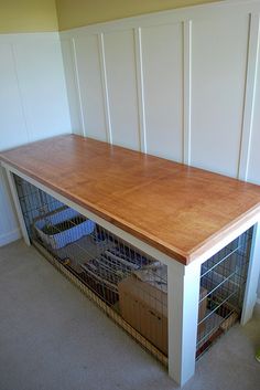 a wooden bench with caged animals in it's center area on carpeted floor