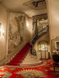 an image of a staircase in the middle of a room with red carpet and white walls