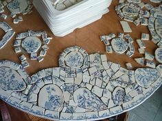 blue and white plates sitting on top of a wooden table