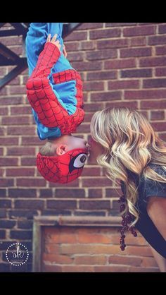 two people are kissing in front of a brick wall and one person is upside down