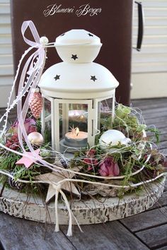 a white lantern sitting on top of a wooden table