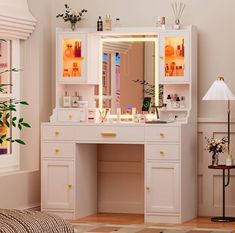 a white vanity with lighted mirror and drawers