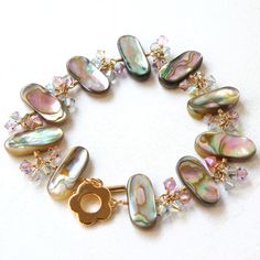 Boho chic and unique artisan style abalone shell bracelet features taupe beige California abalone shells, blush pink Swarovski crystal dangles to create a one of a kind artisan gift for a woman who loves boho chic and eloquent abalone shell jewelry. Dressy enough for the blushing bride. Bracelet Details: - 14k gold filled - Abalone shells bracelet length is 7.5 - 8.5 inches long - Adjustable - clasp anywhere at the end of the chain; the extra chain becomes part of the elegant dangle design. - Ab Elegant Adjustable Mother Of Pearl Beaded Bracelets, Adjustable Natural Stone Beaded Bracelets For Wedding, Adjustable Mother Of Pearl Bracelets For Weddings, Adjustable Mother Of Pearl Wedding Bracelets, Adjustable Oyster Pearl Bracelet, Adjustable Mother Of Pearl Bracelets With Oyster Design, Adjustable Mother Of Pearl Oyster Bracelet, Bohemian Mother Of Pearl Bracelet, Elegant Adjustable Shell Bracelet