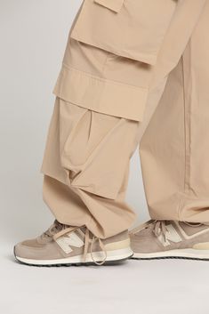 NEW Limited Edition & custom designed Desert Sand Parachute Pants! Not only did we spend months designing these amazing cargo style pants, but we PERFECTED them in the process! These pants are insanely versatile due to their lightweight material and trendy style. They feature adjustable ankle cuffs that you can leave wide or tie up for a jogger look. The elastic waist-band allows for a comfortable fit and the multiple pockets provide great functionality. These pants easily can be worn for any wo Techwear Ankle-length Cargo Pants, Khaki Ankle-length Cargo Parachute Pants, Khaki Cargo Ankle-length Parachute Pants, Khaki Cargo Style Ankle-length Parachute Pants, Khaki Ankle-length Parachute Pants With Cargo Pockets, Beige Parachute Pants With Tapered Leg And Side Pockets, Beige Cargo Ankle-length Pants, Beige Cargo Pocket Ankle-length Pants, Beige Tapered Leg Parachute Pants With Cargo Pockets