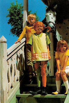 three children are standing on the steps with a horse in the backgroung