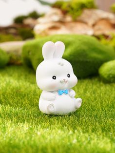 a small white rabbit figurine sitting in the grass