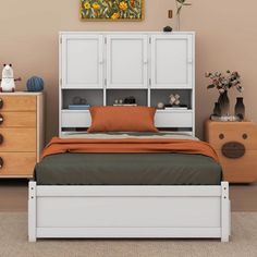 a white bed sitting next to a wooden dresser