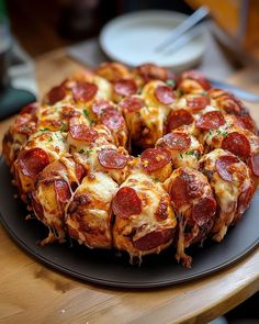 a pepperoni pizza sitting on top of a black plate