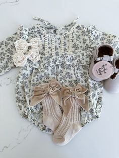 This long sleeve baby romper features a high neck and ruffled trim, perfect for keeping your little one stylish and comfortable. Made from soft cotton material, this romper also sports a beautiful floral print, adding a touch of charm and sophistication to any outfit. Cute Long Sleeve Bubble Romper For Spring, Cute Cream Onesie For Spring, Cute Long Sleeve Cream Bubble Romper, Spring Onesie With Ruffles, Cream Long Sleeve Bubble Romper For Summer, Spring Long Sleeve Ruffled Onesie, Long Sleeve Cream Onesie For Spring, Cream Long Sleeve Onesie For Spring, Cream Long Sleeve Onesie For Fall