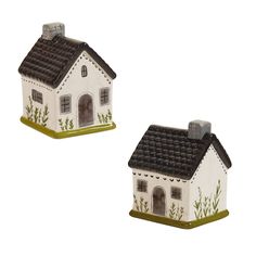 two small white houses with black roofs and green trimmings on each one side