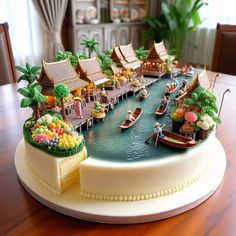 there is a cake that looks like a village on the water with boats in it