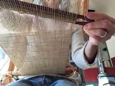 an older woman is working on some type of weaving project with her hands and fingers