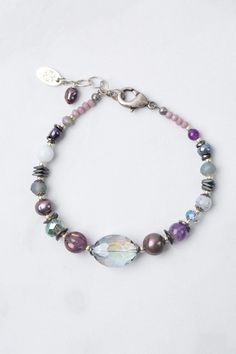 Experience the beauty and versatility of the Reflections Collection. Each piece is thoughtfully handcrafted using carefully chosen materials. This simple collage bracelet measures 7.5-8.5" and is completed an antique silver plated brass extender chain and lobster claw clasp. Elevate your style with Reflections. Antique Silver Plated Brass (lead and nickel free) Amethyst, Blue Lace Agate, Pearl 7.5-8.5", adjustable with antique silver plated brass lobster claw clasp We hand select our natural mat Czech Beads Jewelry Bracelets, Adjustable Sterling Silver Beaded Fusion Bracelets, Silver Crystal Bracelet With Agate Gemstone Beads, Silver Agate Crystal Bracelet With Gemstone Beads, Silver Agate Gemstone Beads Crystal Bracelet, Silver Agate Crystal Bracelet As Gift, Elegant Silver Agate Beaded Bracelets, Silver Agate Crystal Bracelet For Gift, Artisan Purple Bracelet Jewelry