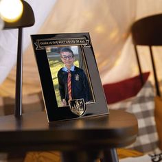 a photo frame with an image of a boy in a harry potter uniform on it