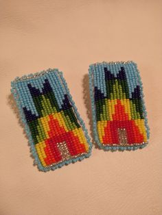 two colorful beaded earrings sitting on top of a white surface