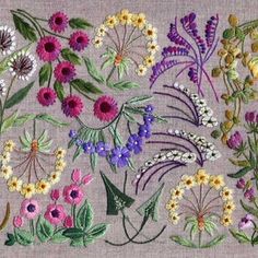 an embroidered piece of cloth with various flowers on the front and back, all in different colors