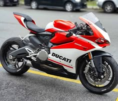 a red and white motorcycle parked on the street