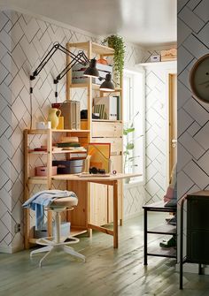 a room with a desk, chair and bookshelf on the wall in it