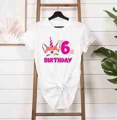 My 6th Birthday Unicorn Shirt, 6th Birthday Shirt, 6 Year Old Birthday, Six Birthday Shirt, Girl Birthday Shirt, Sixth Birthday Shirt HOW TO PLACE YOUR ORDER * Choose your t-shirt color * Choose your size * Choose your design&text color * PLEASE make sure all your order's steps PRODUCT DESCRIPTION T-shirt feels soft and light, with just the right amount of stretch. It's comfortable and the unisex cut is flattering for both men and women. * Solid colors are 100% combed and ring-spun cotton * Ash color is 99% combed and ring-spun cotton, 1% polyester * Heather colors are 52% combed and ring-spun cotton, 48% polyester * Athletic and Black Heather are 90% combed and ring-spun cotton, 10% polyester * Heather Prism colors are 99% combed and ring-spun cotton, 1% polyester * Fabric weight: 4.2 oz/ Cute Unicorn Print Birthday T-shirt, Birthday Unicorn Print Crew Neck T-shirt, Pink Unicorn Print T-shirt For Birthday, Birthday White T-shirt With Unicorn Print, Fun Unicorn Print Top For Birthday, Fun Unicorn Print Tops For Birthday, White Unicorn Print T-shirt For Birthday, White Unicorn Print Top For Birthday, White T-shirt With Unicorn Print For Birthday