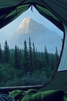 the view from inside a tent looking at a mountain