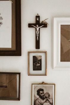 a wall with pictures, framed photos and a crucifix