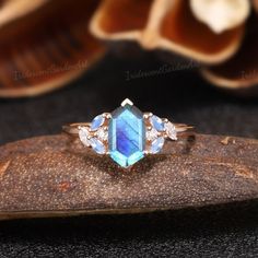 a blue and white stone ring sitting on top of a piece of wood