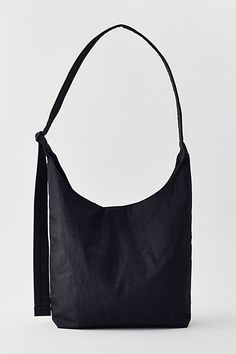 BAGGU large nylon sling bag in a bucket bag silhouette crafted from lightweight nylon. This large BAGGU bag is finished with an interior zip pocket and adjustable shoulder bag strap. Features BAGGU large nylon sling bag BAGGU bag in bucket bag silhouette Interior zipper pocket Fits a 13" /14" laptop Adjustable strap Snap closure Content + Care 100% Nylon (59% recycled) Machine wash Imported Size Strap: 47" adjustable Dimensions: 12.5" w x 5.5" d x 13.5" h | BAGGU Large Nylon Sling Bag in Black, Baggu Bag, Baggu Bags, Silhouette Crafts, Reusable Bags, Nylon Bag, Black Fits, Bag Straps, Sling Bag, Bucket Bag