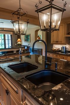 a kitchen with an island and two lights hanging from it's ceiling over the sink