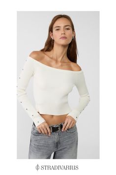 Fitted knit sweater with a straight neckline, exposed shoulders and long sleeves with metal eyelets. Available in assorted colours.