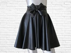 This is a modern and funky twist on your traditional skater skirt. The high waist, center front bow and faux leather gives it that high fashion edge we all love and adore! The bow skater skirt can easily be dressed up or dressed down. Available in sizes XS - 4XL PLEASE view size chart provided before ordering From waist (not top of waistband) to hem this skirt measures 17 inches long ( can be lengthened by request for an additional fee) Ther are no returns accepted for my custom-made items, even exchange or merchandise credit only! In order to receive an even exchange or merchandise credit the item must be returned unworn with all tags attached. The item must be free of any soilage, stains, perfume smells or any other odors. Chic High-waisted Pleated Party Skirt, Fitted Flared Skort For Party, Chic High Waist Pleated Party Skirt, Chic High Waist Pleated Skirt For Party, Trendy Party Skort With Flared Skirt, Flared Skirt With Bow Detail, Flared Skirt With Bow, Trendy Party Flared Skort, Elegant Flared Skort For Party