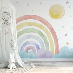 a child's room with a rainbow wall mural and a white teddy bear on the floor