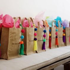 many bags with tassels are lined up on a bench