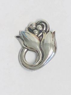 Vintage Georg Jensen Tulip Pin Sterling Silver double Flower Brooch.Stamped Georg Jensen --Sterling---Denmark--100A.The pin closes with safety clasp. weight; 6.2 grams . Condition: PRE-OWNED. Classic Flower Brooches For Anniversary, Vintage Silver Flower Pins, Vintage Silver Lapel Pin For Anniversary, Vintage Silver Anniversary Lapel Pin, Silver Vintage Anniversary Lapel Pin, Classic Silver Pins For Anniversary, Classic Silver Lapel Pin For Anniversary, Mens Sterling Silver Necklace, Peridot Bracelet