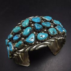 TIMOTHY LEE (NAVAJO) BLUE KINGMAN TURQUOISE STERLING SILVER CUFF BRACELET DESCRIPTION:  With breathtaking specimens of blue Kingman turquoise that cover the entire cuff, along with applied raindrops and chisel stamped accents, this bracelet will be a cherished addition to your collection of fine vintage Southwestern and Native American jewelry. MEASUREMENTS: Interior of the cuff measures 6" with an additional 1 1/4" non-adjustable gap. Total circumference:  7 1/4" Measures 2 1/2" straight across Southwestern Blue Cuff Jewelry, Artisan Blue Cuff Bracelet, Bohemian Blue Cuff Bracelet, Adjustable Southwestern Blue Cuff Bracelet, Western Style Blue Bangle Jewelry, Southwestern Style Blue Bangle Bracelets, Southwestern Blue Cuff Bracelet As Gift, Southwestern Style Blue Bangle Bracelet, Artisan Blue Bracelets Collectible