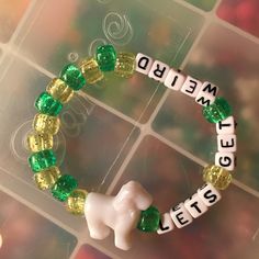 a close up of a beaded bracelet on a glass surface with words spelled in small letters