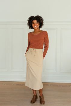 Perfect for everyday wear without loosing it's feminine essence, the 'Chamberlain' skirt will easily be an essential piece in your closet this fall! The skirt features a tie waistband, pockets, and is a modest midi length. Dress it up for a night out, or down for cozy day at home. 85% Polyester, 15% Cotton Unlined Hand Wash Cold Hang or Lay Flat to Dry Do Not Bleach Model Height 5'9" | Wearing Size Small Wearing the 'Nikki' Ribbed Striped Long Sleeve Top in rust with the 'Chamberlain' Tie Waist Everyday Fall Lined Skirt, Modest Fall Skirt, Fall Daywear Skirt With Pockets, Beige Casual Skirt For Loungewear, Casual Beige Skirt For Loungewear, Fall Midi Skirt With Side Pockets, Beige Skirt For Daywear In Fall, Beige Casual Loungewear Skirt, Casual Beige Loungewear Skirt